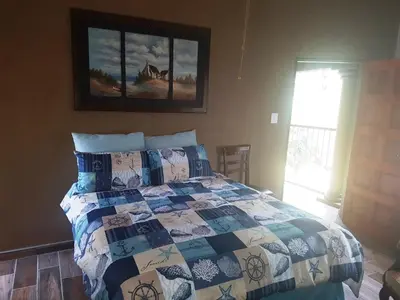 a bedroom with a bed with a quilt on it at Big Boma Guest House in Lydenburg