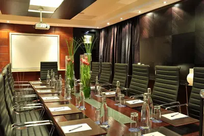 a conference room with a long table and green chairs at Protea Hotel by Marriott Midrand in Midrand