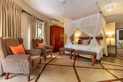 a bedroom with a bed with a canopy at Blue Jay Lodge in Hazyview