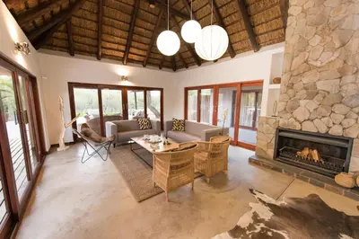 a living room with a large stone fireplace at Unembeza Boutique Lodge & Spa in Hoedspruit