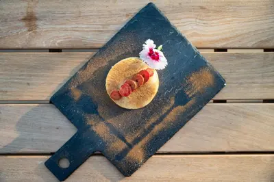 a hot dog on a bun on a wooden table at Unembeza Boutique Lodge & Spa in Hoedspruit