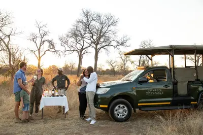 a group of people standing around a table next to a green truck at Unembeza Boutique Lodge & Spa in Hoedspruit