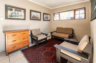 a living room with two chairs and a dresser at The Village in Hatfield in Pretoria