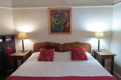 a bedroom with a bed with red pillows on it at The Village in Hatfield in Pretoria