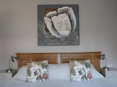 a bedroom with a bed with two pillows and a picture on the wall at The Village in Hatfield in Pretoria