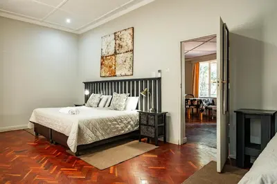 a bedroom with a bed and a mirror at The Village in Hatfield in Pretoria