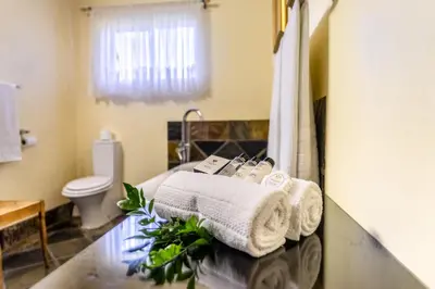 a bathroom with a toilet and towels on a counter at Re a Lora Lodge in Bela-Bela