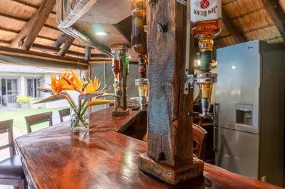 a bar with a wooden counter with a beer dispenser at Re a Lora Lodge in Bela-Bela