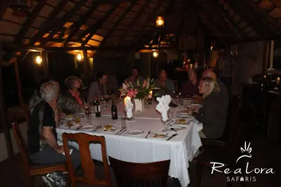 a group of people sitting around a table in a restaurant at Re a Lora Lodge in Bela-Bela