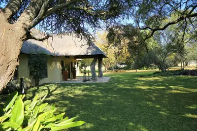 a small building with a grass roof in a field at Re a Lora Lodge in Bela-Bela