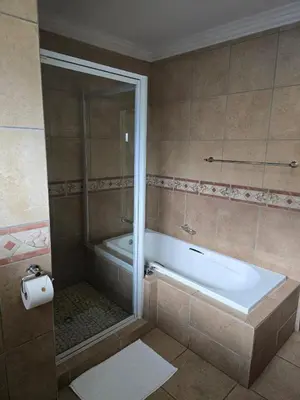 a bathroom with a shower and a tub and a toilet at All Seasons Boutique Hotel - Sustainable Electricity and Water in Pretoria