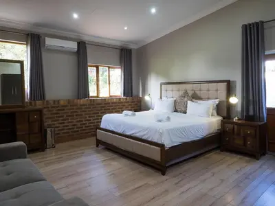 a bedroom with a large bed and a couch at Hotel @ Secunda in Secunda