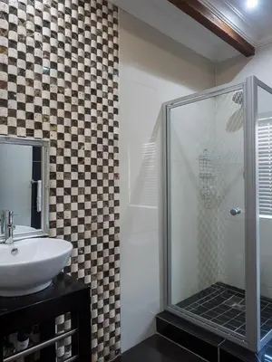 a bathroom with a glass shower and a sink at Hotel @ Secunda in Secunda