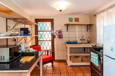 a kitchen with a red chair and a counter top at 3@Marion Guest House in Pretoria