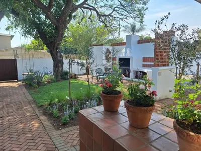 a garden with three potted plants on a patio at 3@Marion Guest House in Pretoria