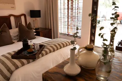 a bedroom with a bed with a tray of food on a table at 3@Marion Guest House in Pretoria