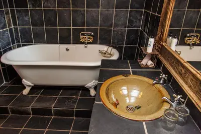 a bathroom with a bath tub and a sink at 3@Marion Guest House in Pretoria