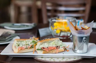 a plate with a sandwich and french fries on a table at City Lodge Hotel at OR Tambo International Airport in Kempton Park