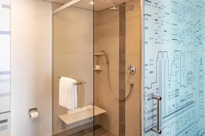 a bathroom with a shower with a glass door at City Lodge Hotel at OR Tambo International Airport in Kempton Park