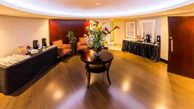 a living room with a table with flowers on it at City Lodge Hotel at OR Tambo International Airport in Kempton Park