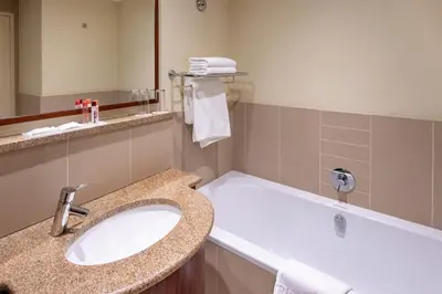 a bathroom with a sink and a bath tub at City Lodge Hotel at OR Tambo International Airport in Kempton Park