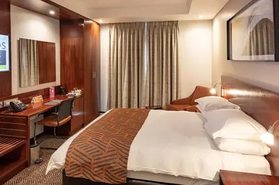 a hotel room with a bed and a desk at City Lodge Hotel at OR Tambo International Airport in Kempton Park
