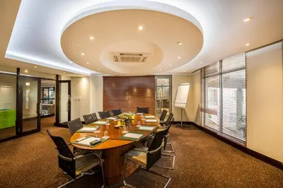 a conference room with a large wooden table and chairs at City Lodge Hotel Lynnwood in Pretoria