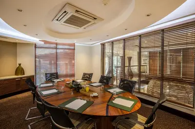 a conference room with a wooden table and chairs at City Lodge Hotel Lynnwood in Pretoria