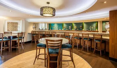 a bar in a restaurant with a table and stools at City Lodge Hotel Lynnwood in Pretoria