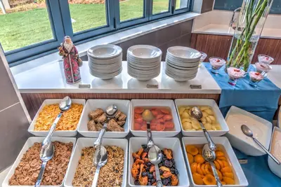 a buffet with several trays of food on a table at City Lodge Hotel Waterfall City in Midrand