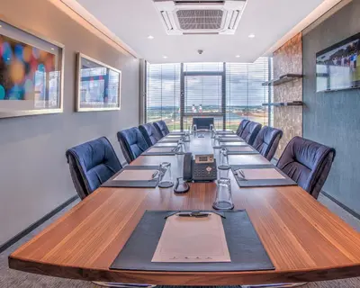 a conference room with a long table and chairs at City Lodge Hotel Waterfall City in Midrand