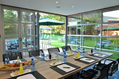 a long table in a room with glass windows at Town Lodge Menlo Park in Pretoria