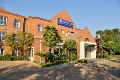 a building with a sign on the front of it at Town Lodge Menlo Park in Pretoria
