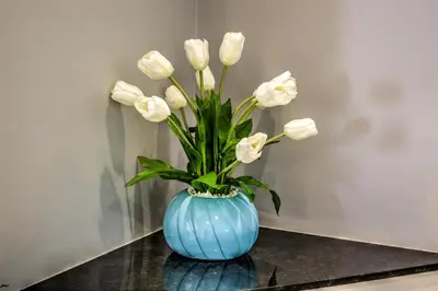 a blue vase filled with white flowers on a table at Town Lodge Waterfall, Midrand in Midrand