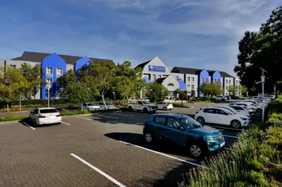a parking lot with cars parked in front of houses at Town Lodge Waterfall, Midrand in Midrand