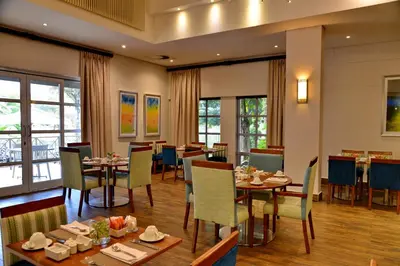 a dining room with tables and chairs and windows at Town Lodge Mbombela in Nelspruit
