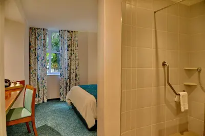 a bathroom with a bed and a shower in a room at Town Lodge Mbombela in Nelspruit