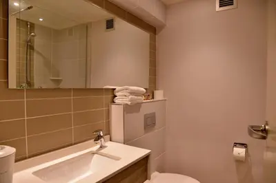 a bathroom with a sink and a toilet and a mirror at Town Lodge Mbombela in Nelspruit