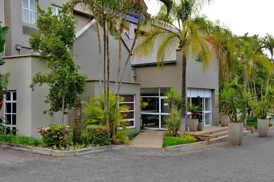 a building with palm trees in front of it at Town Lodge Mbombela in Nelspruit