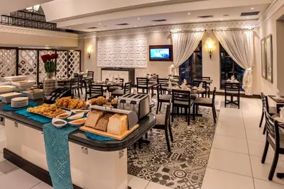 a breakfast buffet in a restaurant with tables and chairs at Town Lodge Polokwane in Polokwane