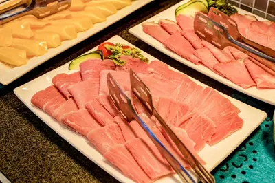 a table topped with plates of food with meat and cheese at Town Lodge Polokwane in Polokwane