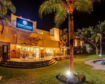 a building with a palm tree in front of it at Town Lodge Polokwane in Polokwane
