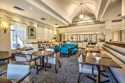 a restaurant with tables and chairs and a couch at Town Lodge Polokwane in Polokwane