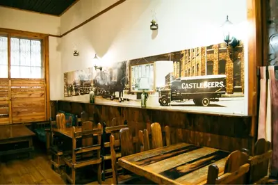 a restaurant with a table and chairs and a picture of a truck at The Grey's Inn in Machadodorp