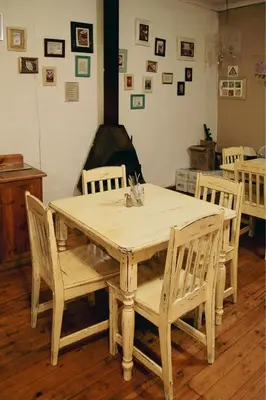 a wooden table with four chairs and a fireplace at The Grey's Inn in Machadodorp