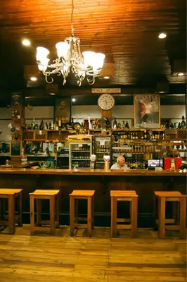 a bar with wooden stools in a restaurant at The Grey's Inn in Machadodorp