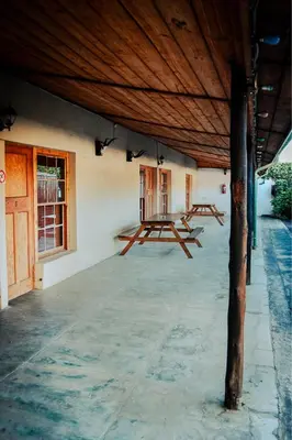 two picnic tables on the side of a building at The Grey's Inn in Machadodorp