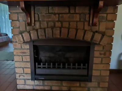 a brick fireplace with a fire place at Kloofsig Holiday Cottages in Graskop