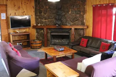 a living room with couches and a stone fireplace at The Stix in Dullstroom