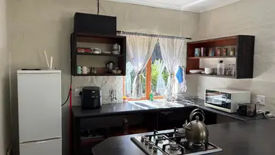 a kitchen with a stove and a sink and a window at The Stix in Dullstroom